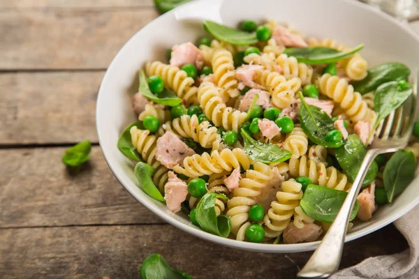 Macarrão fusilli com salmão, espinafre e ervilhas verdes — Fotografia de Stock