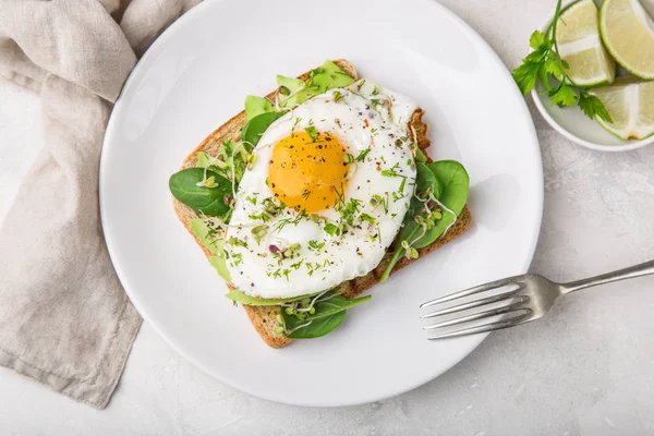 Toast with avocado, spinach and fried egg — Stock Photo, Image