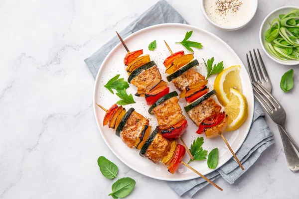 Brochettes de saumon et légumes grillés sur assiette blanche — Photo