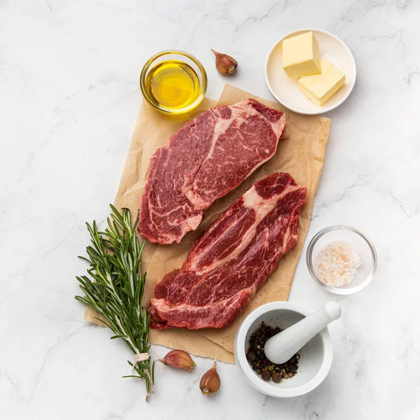 Fresh raw beef steaks with ingredients — Stock Photo, Image