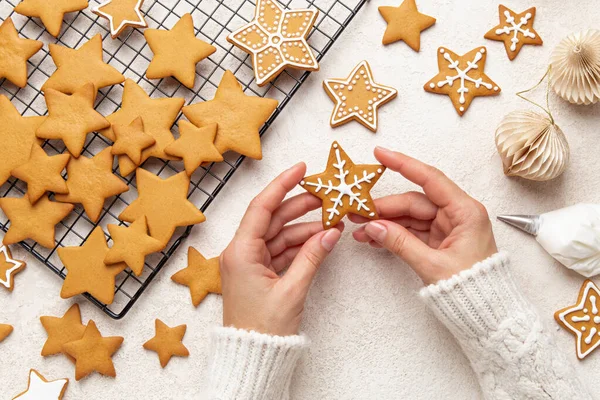 クリスマスジンジャーブレッドクッキーを飾る女性の手の閉じる — ストック写真