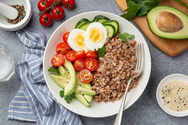 Здоровий веганський обідня миска з авокадо, яйцем, огірком, помідорами і — стокове фото