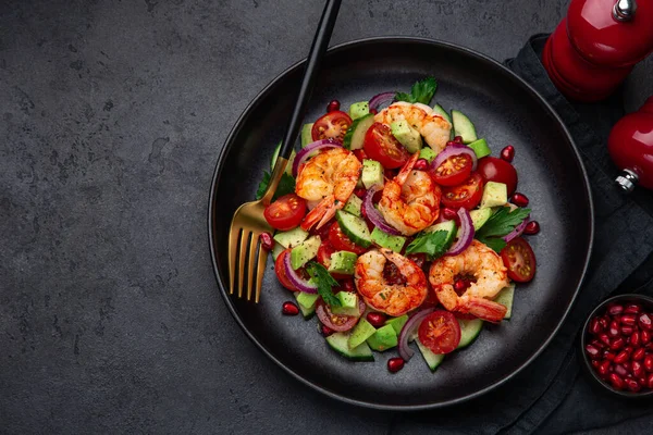 Salade de crevettes grillées et légumes sur assiette noire — Photo