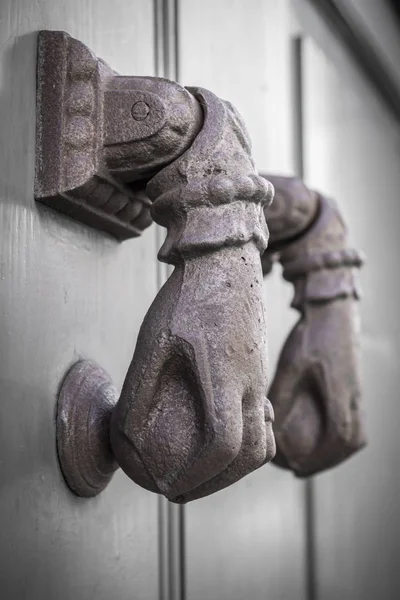 Rusty hand shaped knocker in an old door. Defocused blurry background. — Stock Photo, Image