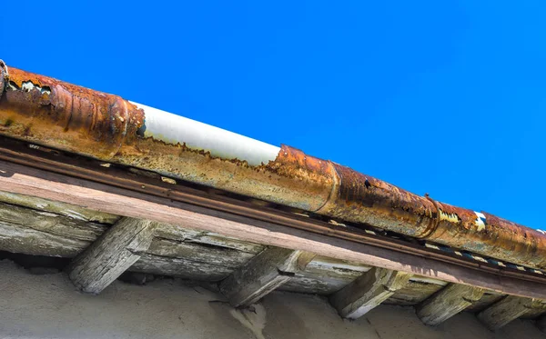 A broken gutter on the roof of a house — Stock Photo, Image