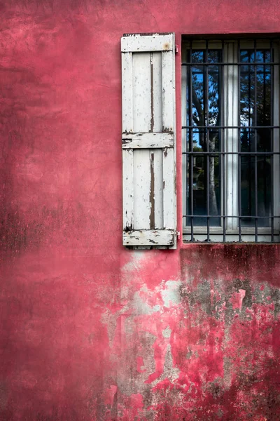 Decorative grungy window on an old red stucco wall — Stock Photo, Image