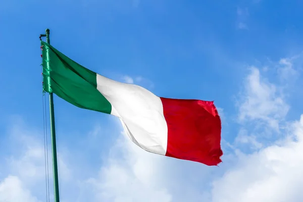 Waving Italian flag against blue sky