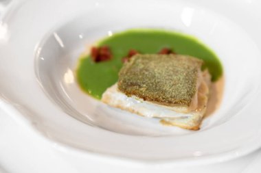 Ekmek kabuğunun altında kızarmış balık filetosu.