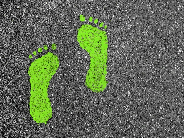 Green footprints on asphalt — 스톡 사진