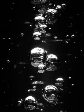Karanlık arkaplanda metin alanı ile su kabarcıkları oluşturur. Siyah arka planda beyaz kabarcıklar. Siyah beyaz görüntüler. Karanlık su.