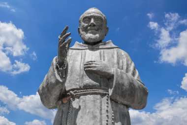 Statue of Saint Father Pio on sky background. Ideal for concepts or events. clipart