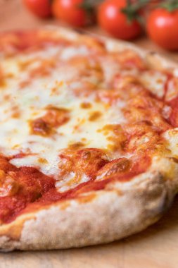 Domates suyu ve mozzarella di bufala peynirli İtalyan pizza margherita 'sının dikey yakın çekimi.