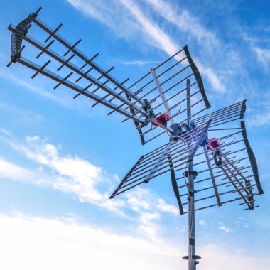 Mavi gökyüzü arkaplanlı televizyon anteni. DVB-T ve DVB-T2 'yi mavi gökyüzüne karşı yayınlayan dijital televizyon yayını için yön anteniName.