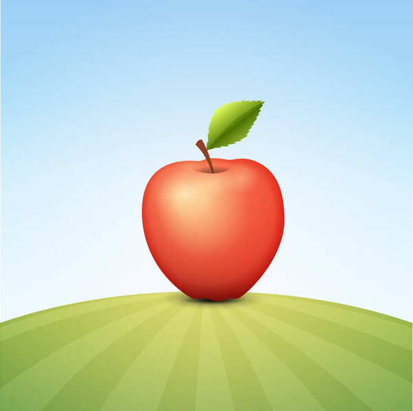 Вкусное красное яблоко на зеленом поле

