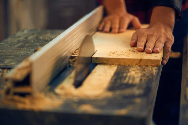 Carpenter cutting wooden plank — Stock Photo, Image