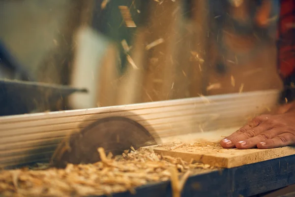 Carpenter cutting wooden plank — Stock Photo, Image