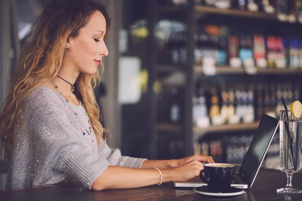 Kvinna som använder laptop i café — Stockfoto