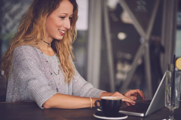 Kvinna som använder laptop i café — Stockfoto