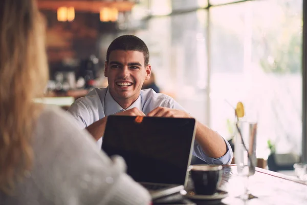Man looking at woman with laptop in cafe — Stock Photo, Image