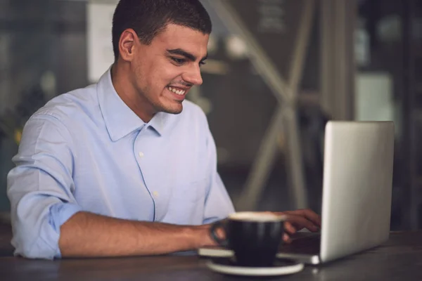 Schöner Mann mit Laptop in Café — Stockfoto