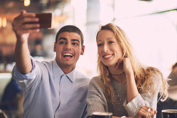 Muž s ženou, takže selfie v kavárně — Stock fotografie