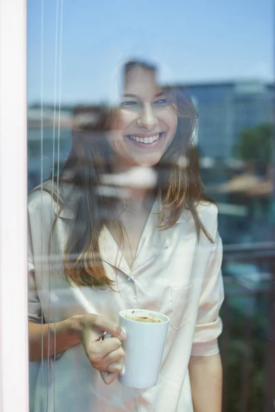 Usmívající se žena u okna — Stock fotografie