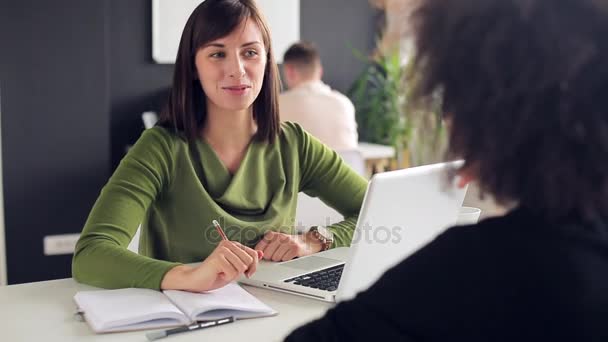 Молодая женщина разговаривает со своим клиентом в офисе — стоковое видео