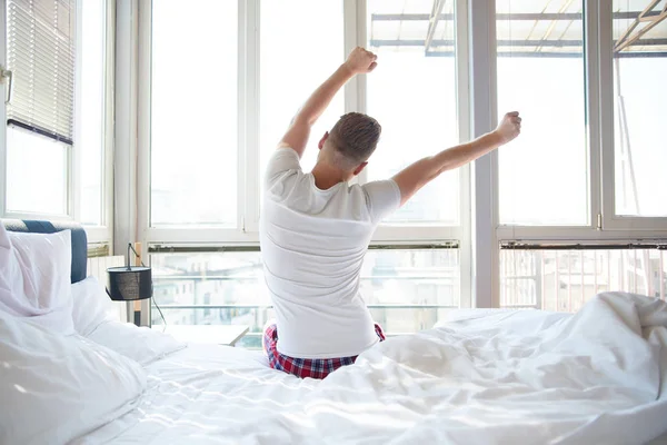 Man die zich uitstrekt in bed — Stockfoto