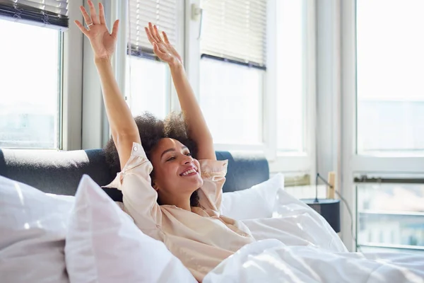 Vrouw in bed in de buurt van windows — Stockfoto