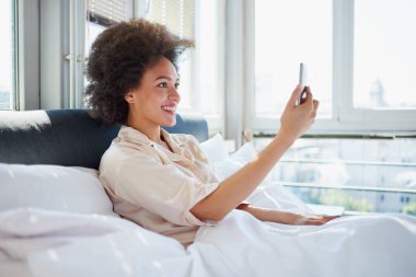 Görüntülü arama yatakta kullanan kadın