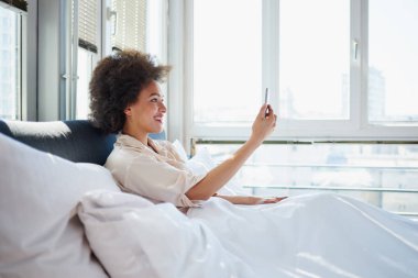 Görüntülü arama yatakta kullanan kadın