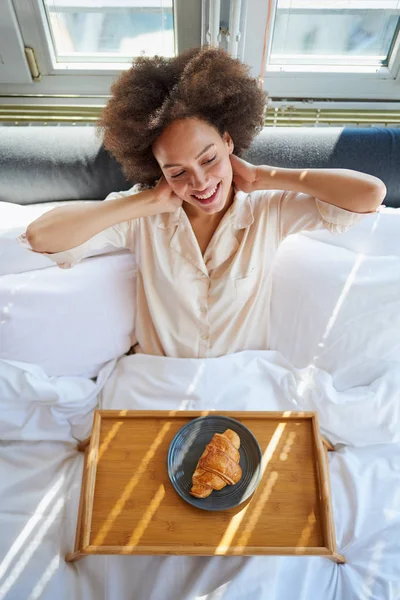 Женщина с подносом для кровати сидит в постели — стоковое фото