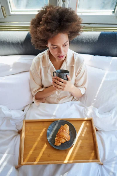 Frau frühstückt im Bett — Stockfoto