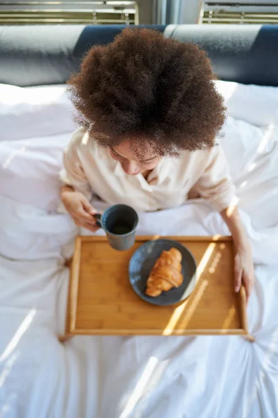 Γυναίκα τρώει πρωινό στο κρεβάτι — Φωτογραφία Αρχείου