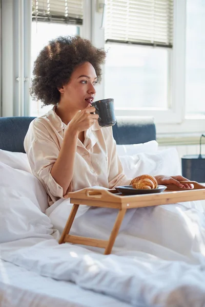 Vrouw drinken's ochtends koffie in bed — Stockfoto