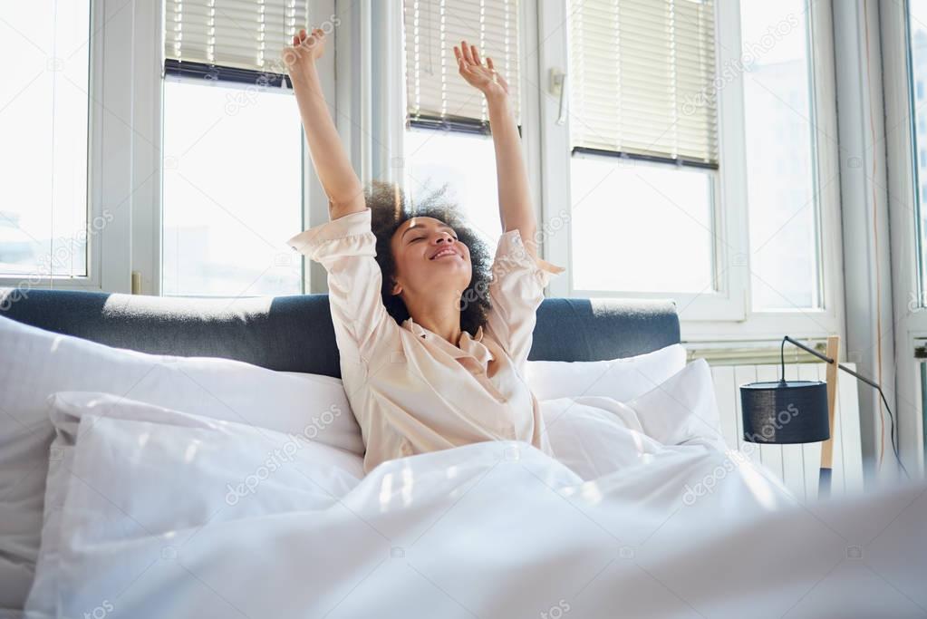 Woman stretching in bed