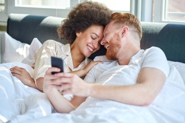 Çift birlikte yatakta gülüyor