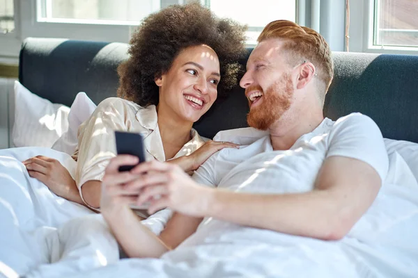 Paar lacht gemeinsam im Bett — Stockfoto