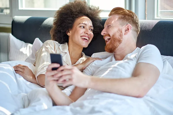 Paar lacht gemeinsam im Bett — Stockfoto