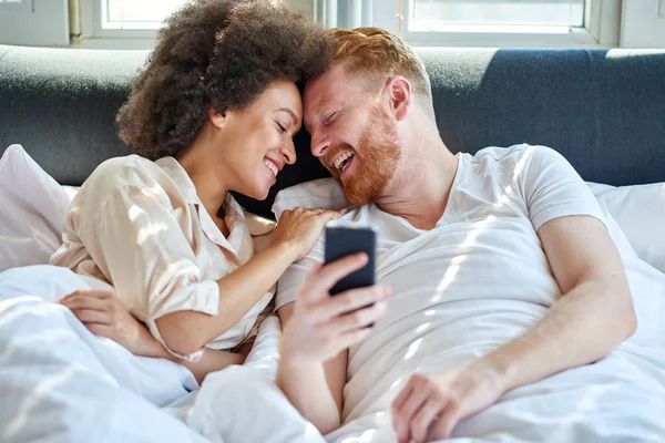 Couple riant ensemble au lit — Photo
