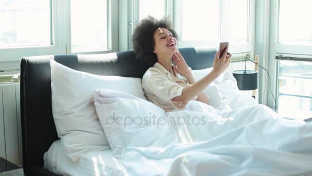 Mulher fazendo chamada de vídeo na cama — Vídeo de Stock
