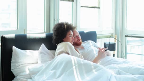 Couple using phone in bed — Stock Video