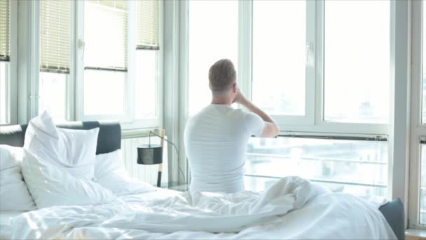 Visão Traseira Jovem Stretchin Branco Sentado Cama Pela Manhã — Vídeo de Stock