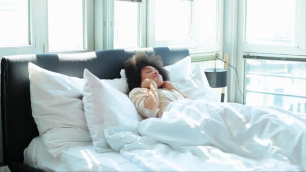 年轻的 African American 女人在床上醒来和伸展 — 图库视频影像