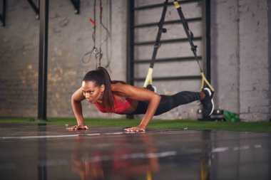 Genç kadın trx halatlar ile katta pratik
