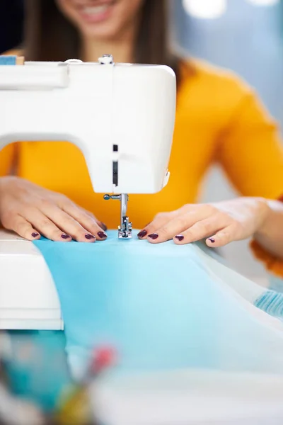 Close up of smiling caucasian seamstress sewing beautiful evening dress. — Stock Photo, Image