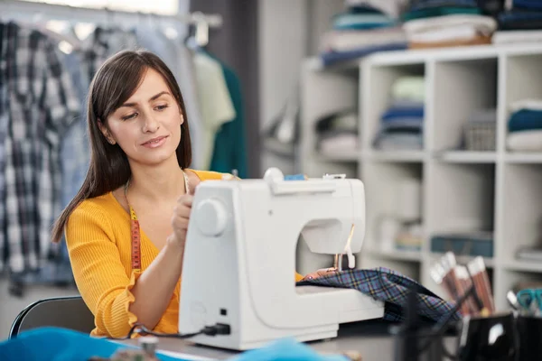 Enfocado encantador diseñador de moda caucásico sentado en su estudio y costura hermoso vestido de noche . —  Fotos de Stock