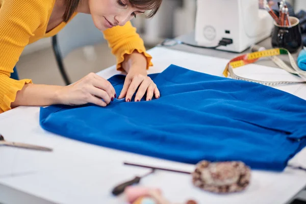 Primer plano de hermosa costurera caucásica enfocada poniendo pin en la costura y haciendo hermosa falda . —  Fotos de Stock