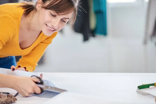 Close-up van vrouwelijke tailor snijden naad patroon voor kleding. — Stockfoto