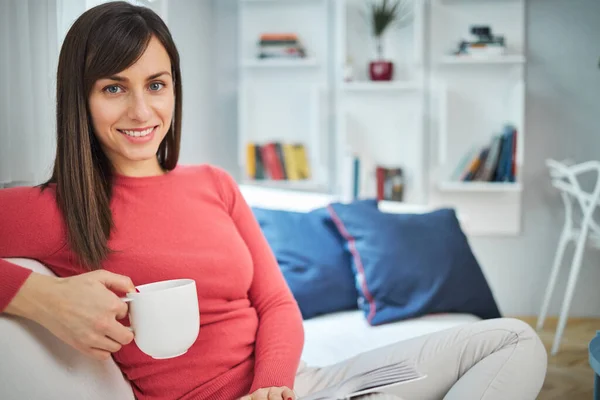 Jovem atraente sorrindo morena relaxante em casa . — Fotografia de Stock